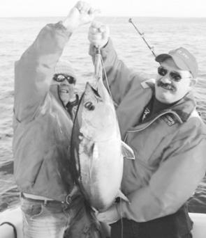 Dave Yanko and Chris Hall were pretty happy with this 14kg tuna, caught while fishing with Bob McPherson.